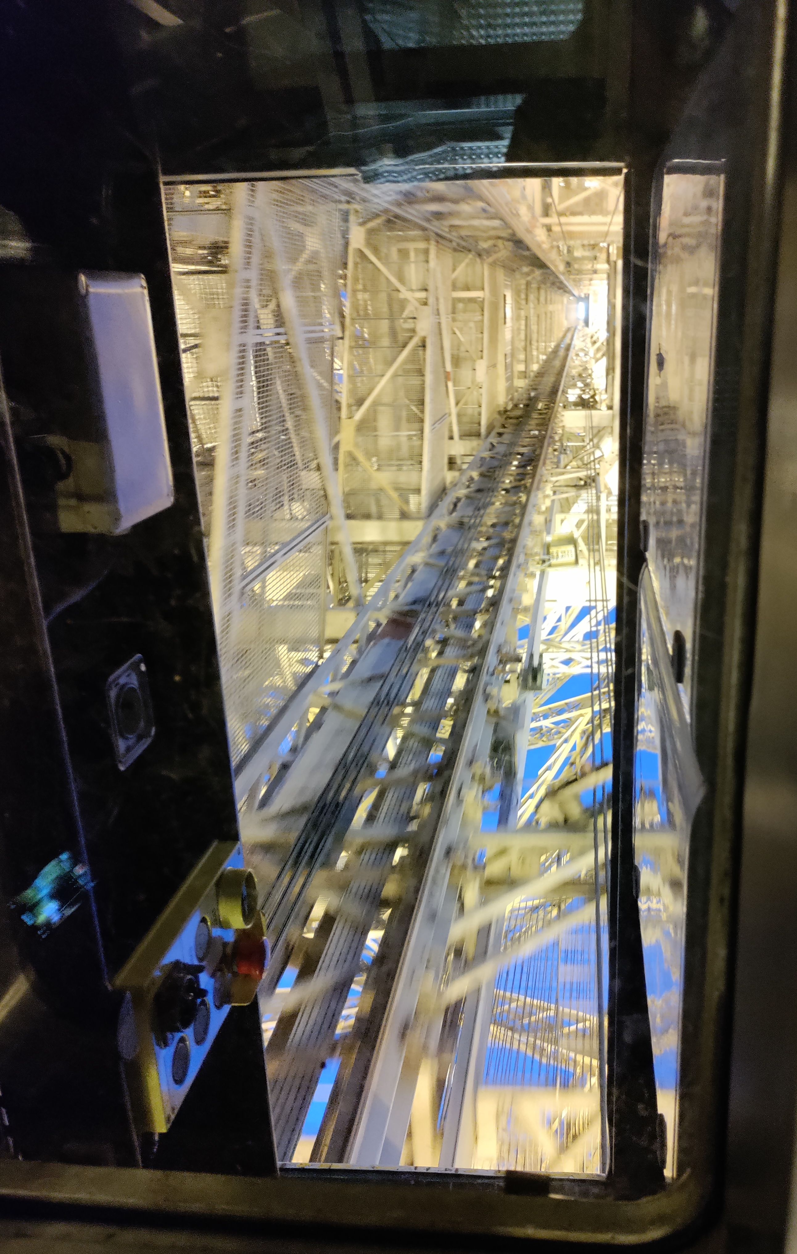 View of the Eiffel Tower from the inside the elevator going up to the top.